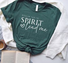 a green shirt that says spirit lead me next to an open book and cup of coffee