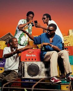 three men are sitting on top of a radio