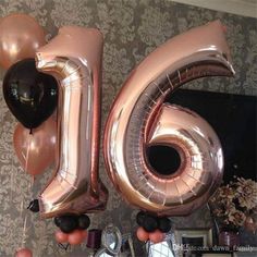 the number sixteen balloon is in front of a fireplace with other balloons and decorations around it