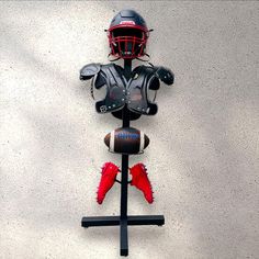 a football helmet mounted to the side of a wall next to a ball and glove holder