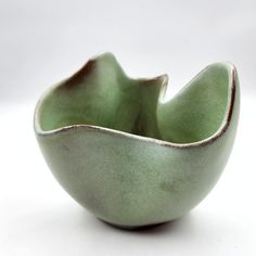 a green bowl sitting on top of a white table