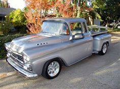 an old silver truck is parked on the street