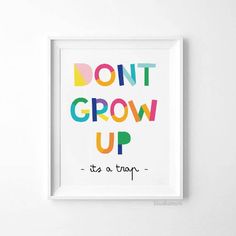 a framed poster with the words don't grow up in multicolored letters