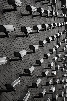 black and white photograph of rows of benches on the side of a building