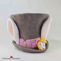 a crocheted hat with an alarm clock on the front and side, made to look like a top hat