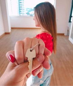 a person holding a key in their right hand and pointing it at the camera with both hands