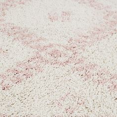 an area rug with pink and white designs on the carpet is seen in this image