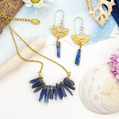 Step into the realm of  our Raw Kyanite Resort Wear Jewelry Set, a masterpiece of natural elegance and island bohemian charm. This captivating set features raw slices of beautiful blue kyanite, forming a stunning crystal ray that adorns your neck with grace and sophistication. The earrings boast a unique silver and brass mix metal design, with a hand-hammered brass half moon embracing a silver new moon, accentuated by a dangling kyanite slice below. Embrace the allure of ethical jewelry with this original handmade set, crafted with fair trade practices to honor both craftsmanship and the environment. Elevate your style with this mesmerizing jewelry set, perfect for resort wear and any occasion that calls for a touch of ethereal beauty. Handmade Bohemian Brass Jewelry Sets, Bohemian Blue Necklace With Raw Stone, Handmade Bohemian Kyanite Jewelry, Luxury Kyanite Jewelry Gift, Luxury Blue Kyanite Jewelry, Blue Kyanite, Ethical Jewelry, Raw Stone, Mixed Metals