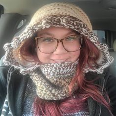 a woman wearing glasses and a knitted hat in the back seat of a car