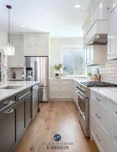 a large kitchen with white cabinets and stainless steel appliances, along with wood flooring