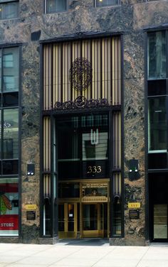 the entrance to an office building that is very tall and has windows on each side