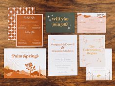 the wedding stationery is laid out on top of the wooden table, including an orange and white card