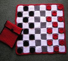 a crocheted checkerboard with red and black circles on it next to a wallet