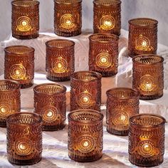 many brown glass candles sitting on top of a table