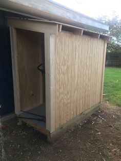 a small wooden shed with the door open