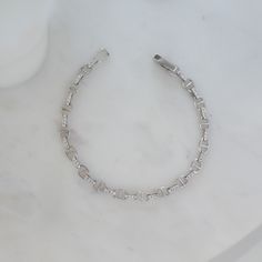 This handmade chain bracelet is dainty and beautiful. It features pave stones that connect each link beautifully! It's great as a gift or for yourself. Great stacked or worn alone! We use a THICK plating of 14k Gold or Rhodium over brass Available in 6.25", 6.75" or 7" Lengths Not adjustable We use the Highest Grade of Cubic Zirconia for an authentic look! Bracelets on Model: Daryl-Ann's Sunburst Bracelet Unsure of your bracelet length? Use our Bracelet Sizer Tool! Silver Tennis Bracelet With Adjustable Chain For Everyday, Cubic Zirconia Bangle Chain Bracelet For Everyday, Everyday Cubic Zirconia Bangle Chain Bracelet, Adjustable Chain Bracelet With Cubic Zirconia, Adjustable Cubic Zirconia Chain Bracelets, Everyday Cubic Zirconia Crystal Bracelet, Elegant Hypoallergenic Crystal Bracelet For Everyday, Dainty Adjustable Bracelet With Solid Link, Everyday Sterling Silver Crystal Bracelet