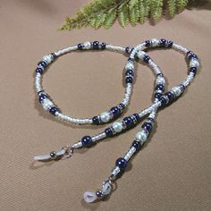 "This Glasses chain has soft blue and white pearl finish glass beads (2 sizes on the blue ones!) and silver rondelles with iridescent mini rhinestones. The glass seed beads are clear with white inserts. It's a sweet gift for someone special to you! Length - 28\" (68.58 cm) Weight - 1.34 oz. (30 grams) Multi-strand stringing wire Silicone ends" Adjustable Silver Beaded Necklace With Pearl Chain, Handmade Silver Pearl Beads, Adjustable Blue Beaded Necklace With Silver Beads, Adjustable Blue Beaded Necklaces, Adjustable Pearl Beads For Party, Silver Beaded Chain With Round Beads, Blue Pearl Beads For Jewelry Making, Blue Pearl Jewelry With Spacer Beads, Blue Pearl Beaded Necklace For Party