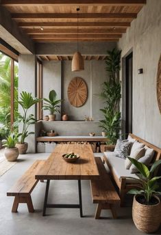 a wooden table sitting next to a white couch in a living room filled with potted plants