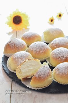 bread rolls on a black plate with sunflowers in the background