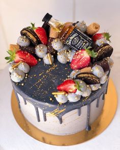 a cake decorated with chocolate, strawberries and other toppings on a gold plate