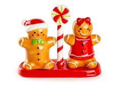 two gingerbread man and woman figurines with candy canes on white background