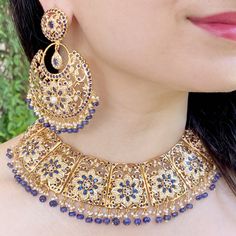 Featuring a gorgeous heavy jadau necklace with chandbali earrings in gold plated sterling silver. This indo western design, handcrafted luxury has been adorned with precious pearls and sapphires beads. The studded navy blue stones are synthetic that very closely resemble blue sapphires. This necklace set is crafted with the best of metals and decorated with elegant pearls and sapphires. Enjoy a truly luxurious experience with a high-quality gold plated sterling silver finish. Gold Plated Chandbali Jewelry With Matching Earrings, Heavy Jewelry For Eid Celebration, Elegant Chandbalis For Eid Ceremonies, Gold Plated Chandbali Bridal Necklace, Ornate Chandbali Jewelry With Stone Work, Diwali Heavy Gold Plated Jewelry, Meenakari Chandbali Jewelry For Eid, Gold Plated Chandbali Bridal Necklace With Cutdana, Ornate Chandbali Bridal Necklace