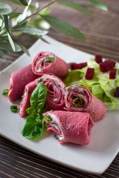 a white plate topped with meat and veggies on top of a wooden table