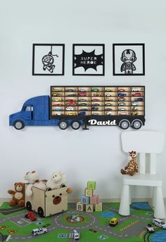 there is a toy truck on the wall with pictures above it and toys in front of it