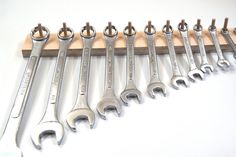 a bunch of wrenches are lined up on a board