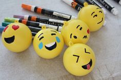 four yellow emoticions with faces painted on them next to crayons and markers