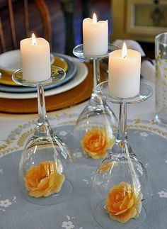 three wine glasses with candles in them sitting on a table