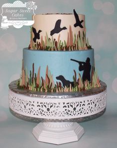 a three tiered cake decorated with grass and birds