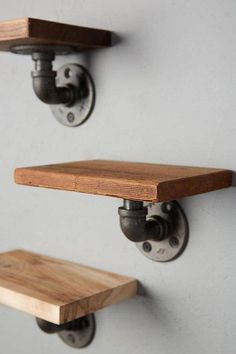 two wooden shelves mounted to the side of a wall with metal fittings on them