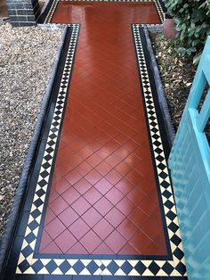 the walkway is made out of red and black tiles