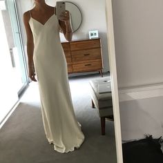 a woman in a white dress taking a selfie