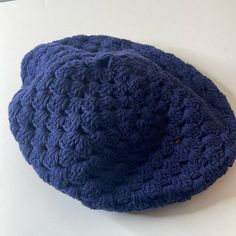 a blue crocheted hat sitting on top of a white table