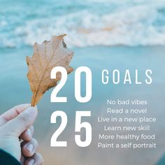 a person holding a leaf with the words 20 goals written below it in front of an ocean