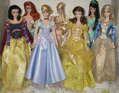 there are many dolls that are standing together in the same room, all wearing different dresses