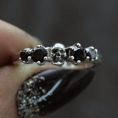 Our beautiful skull wedding ring is set with black spinel either side of one of our tiny anatomical skulls. Originally made by hand and now cast into silver, we size each one of our skull wedding rings by hand to fit you perfectly. ⸸ Metal: Sterling Silver ⸸ Gemstones: Black Spinel ⸸ Weight: approximately 3.5 g Gothic Wedding Rings For Him, Gothic Rings Wedding, Goth Wedding Ring, Skull Wedding Ring, Dream Items, Accessory Inspo, Skull Wedding, Fantasy Stuff, Black Wedding Rings