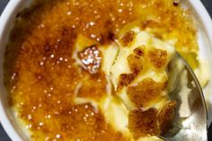 a close up of a spoon in a bowl of food with cheese and sauce on it