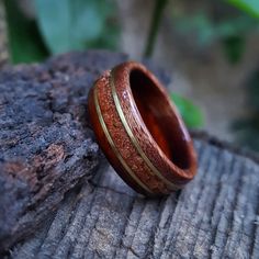 "☉ Cocobolo and Itin exotic south american tropical wood ring with a centered band of crushed Goldstone and Bronze inlays. The Stone has a glimmering like effect with small gold stars, a sparkly one of a kind stone. ☉ * Made to order in all sizes. * Finished with multiple layers of CA achieving a strong high-gloss polish * Extremely durable and water resistant. *Shipping* This item includes free domestic and international shipping. Its delivery process takes from 15 to 20 business days and it do Unique Brown Rings For Anniversary, Unique Brown Jewelry For Anniversary, Nature-inspired Red Rings As Gifts, Nature-inspired Red Rings For Gifts, Unique Brown Jewelry With Inlay, Nature-inspired Brown Jewelry, Unique Mahogany Jewelry For Gift, Nature-inspired Brown Round Jewelry, Earthy Brown Round Jewelry