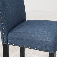 a blue upholstered chair with gold studding