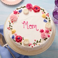 a mother's day cake on a table with purple and white napkins next to it