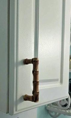 a close up of a door handle on a white cabinet with blue walls in the background