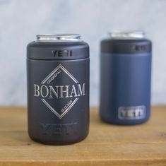 two canisters sitting on top of a wooden table next to each other,