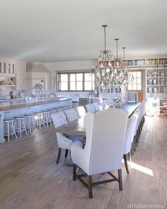 the dining room table is surrounded by white chairs