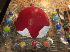 a red cake sitting on top of a glass plate