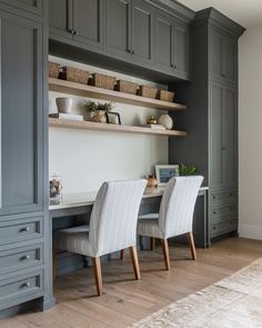 a dining room with gray cabinets and white chairs in front of the counter top area