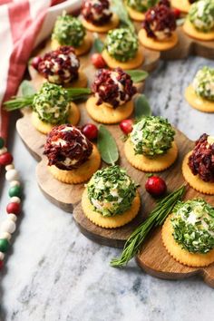 small appetizers are arranged on wooden platters with green and red toppings