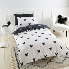 a mickey mouse bed in a white room with black and white decor on the walls